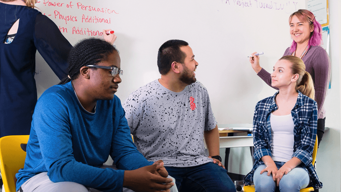 Teachers working together at a whiteboard.
