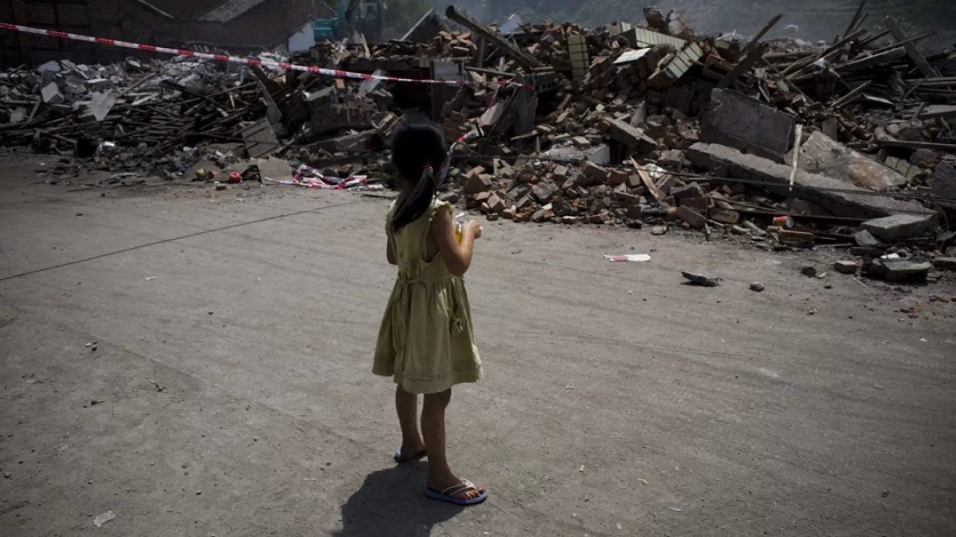A young girl facing earthquake rubble in Wenchuan County, Sichuan.